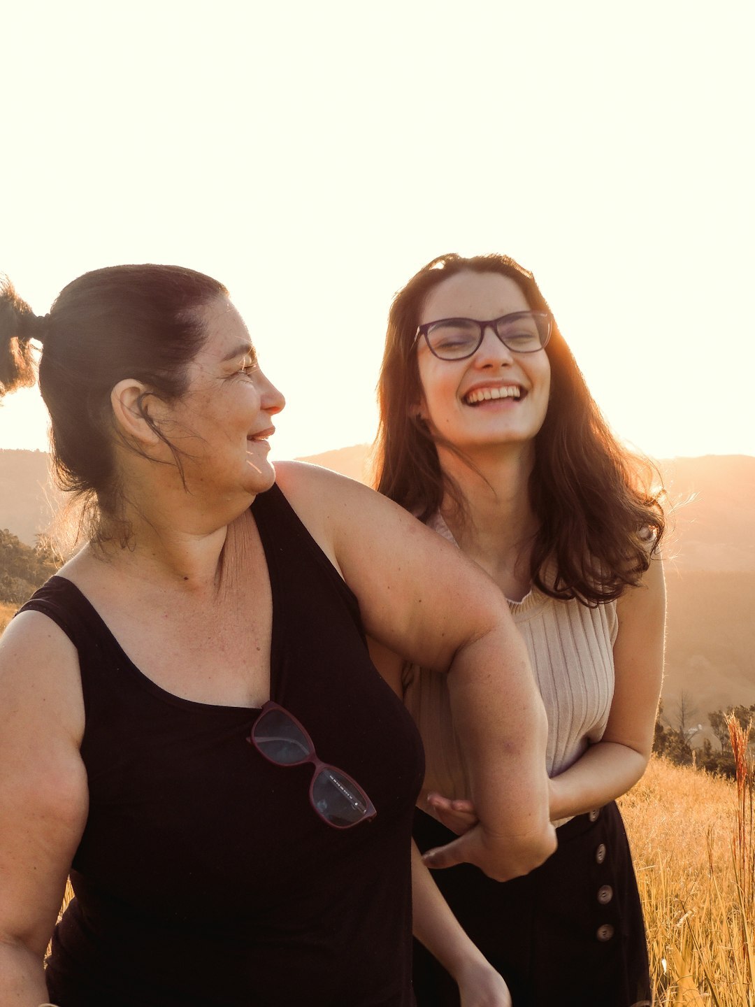 Adult daughter sitting and laughing with her senior mother